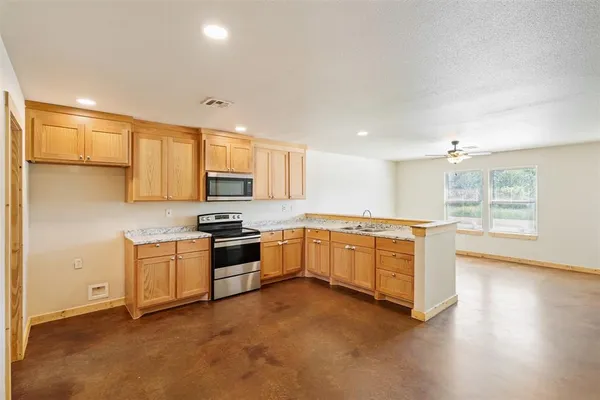 a large kitchen with stainless steel appliances granite countertop a stove and a sink