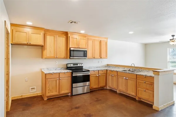 a kitchen with stainless steel appliances granite countertop a stove a sink and a refrigerator