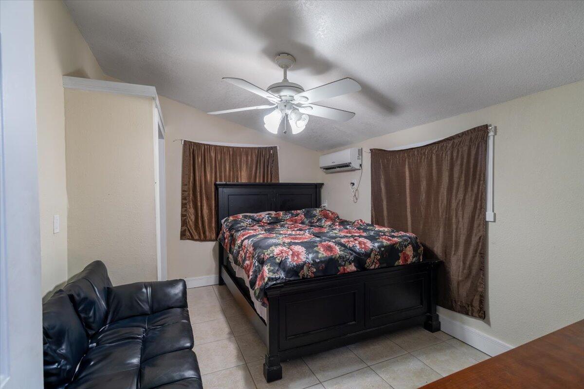 430 80th Street Marathon, FL 33050 - Photo 29 of 44 a bed sitting in a bedroom next to a window with a chandelier