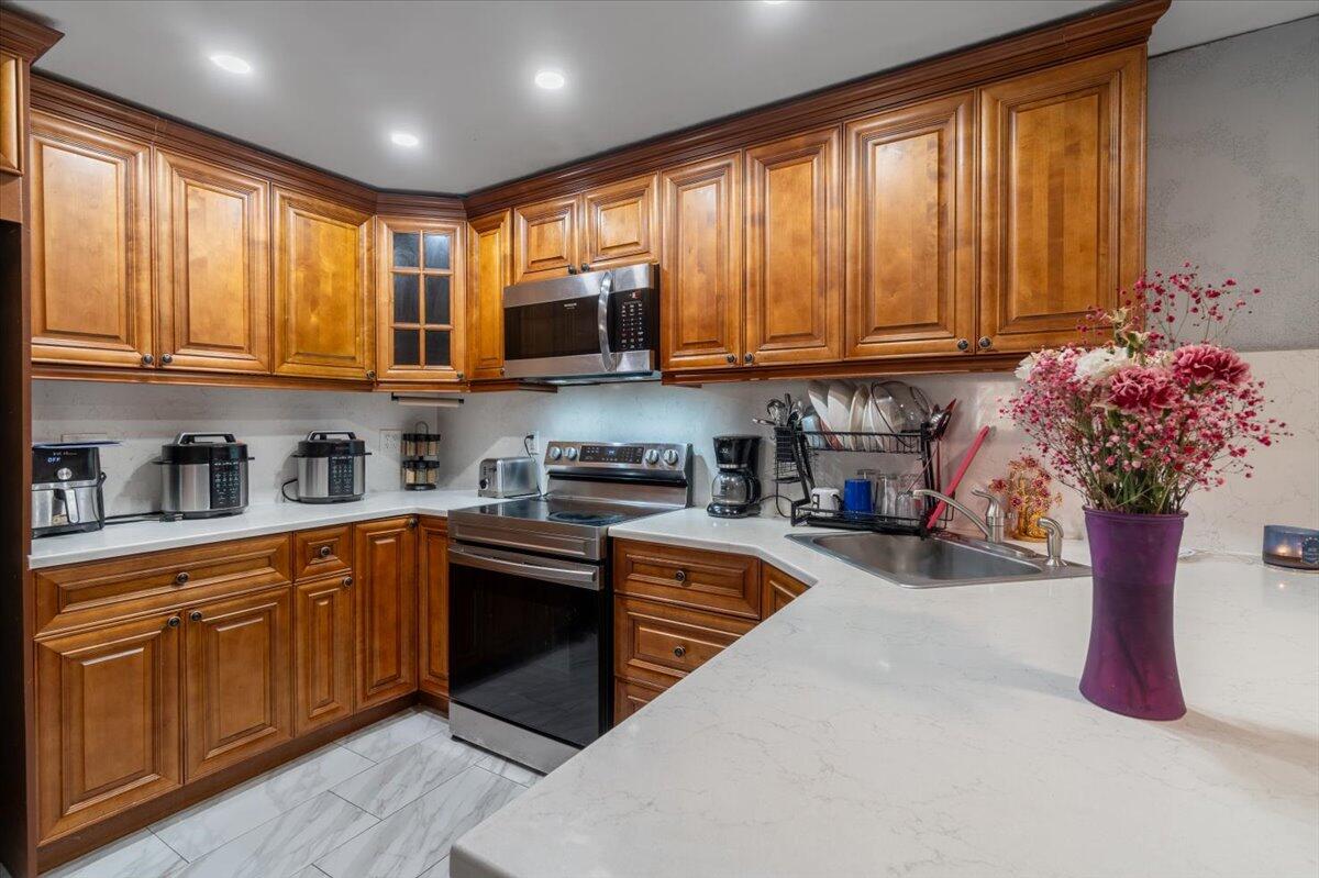 430 80th Street Marathon, FL 33050 - Photo 8 of 44 a kitchen with stainless steel appliances granite countertop a stove a sink dishwasher and a microwave with wooden floor