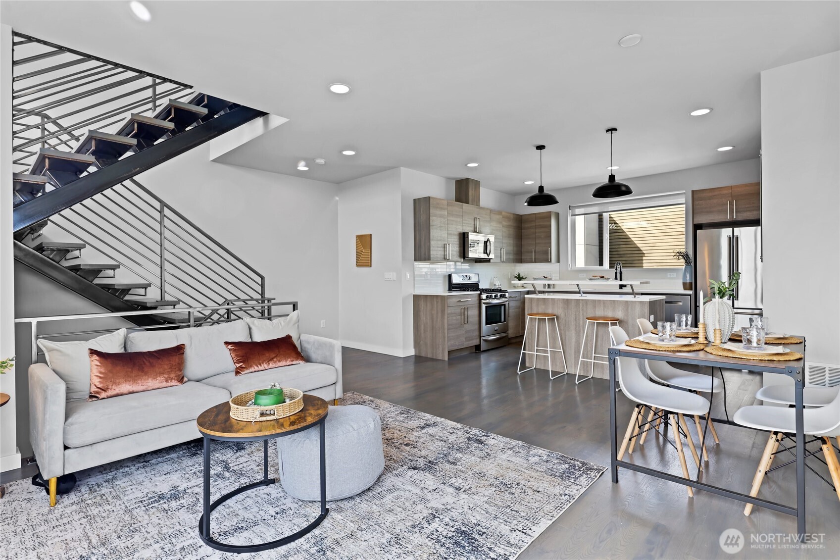2653 Northwest 64th Street, Unit A Seattle, WA 98107 - Photo 1 of 32 a kitchen with stainless steel appliances kitchen island granite countertop a stove a sink a dining table and chairs