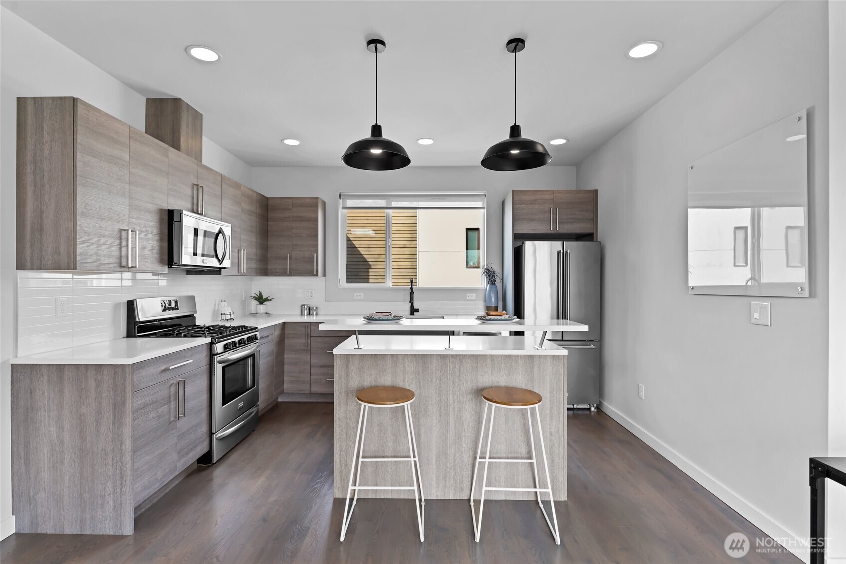 2653 Northwest 64th Street, Unit A Seattle, WA 98107 - Photo 6 of 32 a kitchen with stainless steel appliances granite countertop a stove a sink and a refrigerator