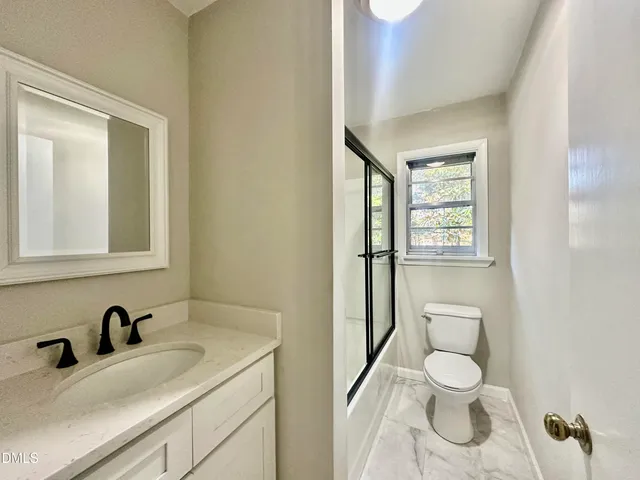 a bathroom with a toilet sink vanity and mirror