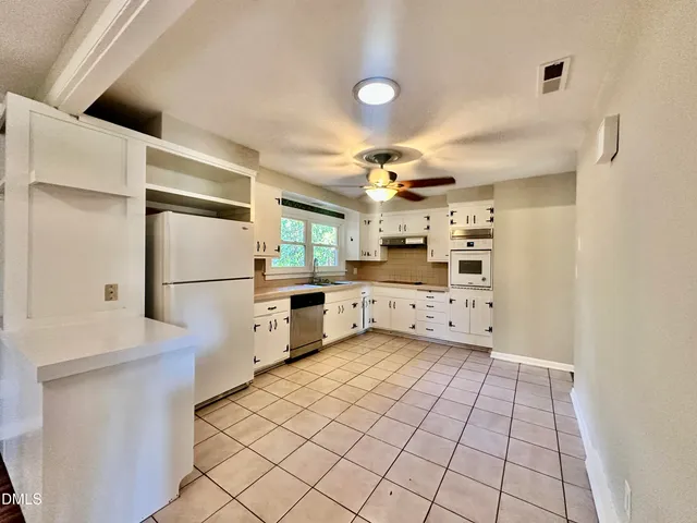 a kitchen with stainless steel appliances a refrigerator and a stove top oven