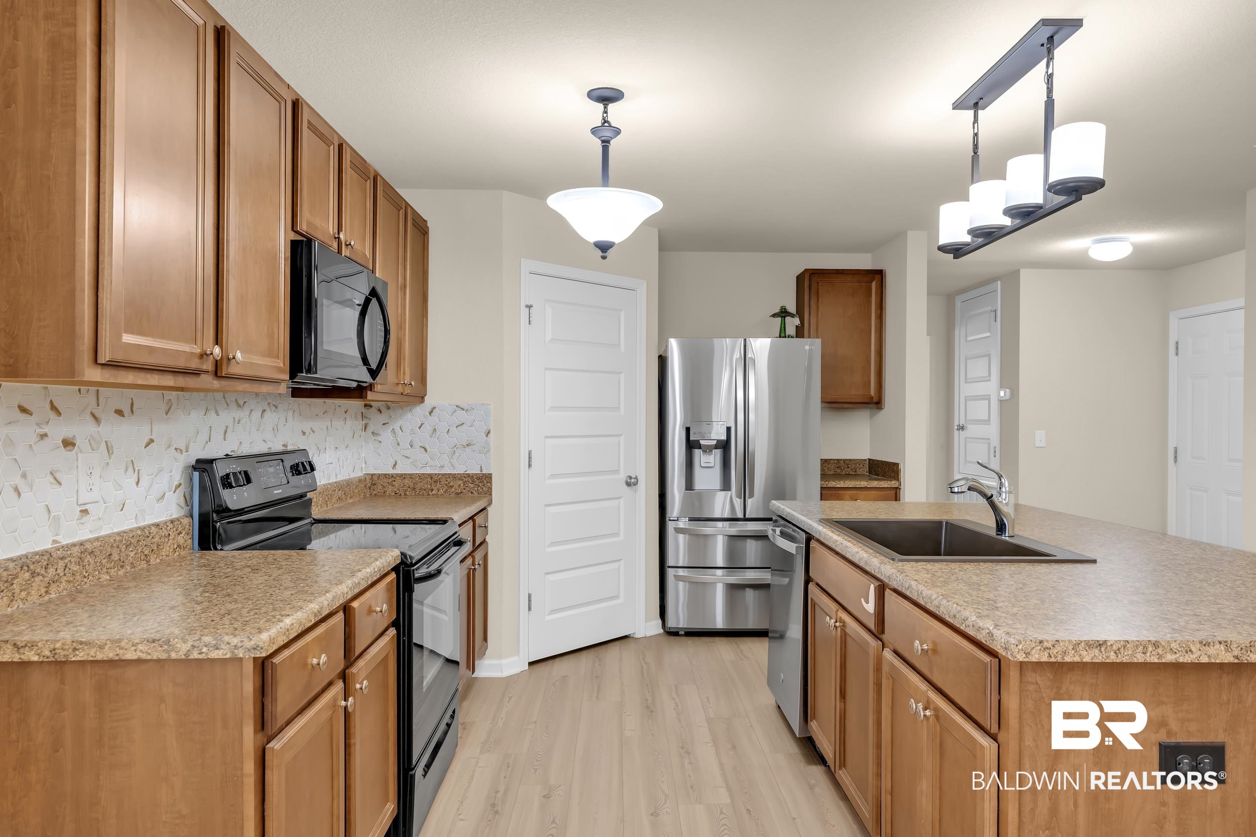 1704 Abbey Loop Foley, AL 36535 - Photo 11 of 38 Kitchen featuring wood cabinetry, speckled countertops, and a full suite of black and stainless steel appliances