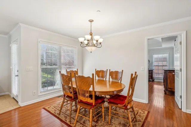 a dining room with furniture a chandelier and wooden floor
