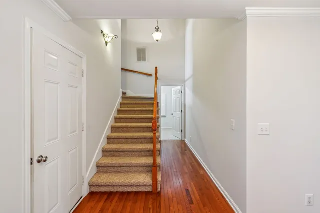 a view of a hallway with wooden floor and entryway
