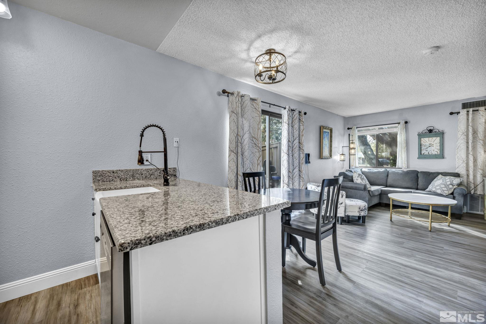 4721 Reggie Road Reno, NV 89502 - Photo 12 of 33 a kitchen with a table chairs and wooden floor