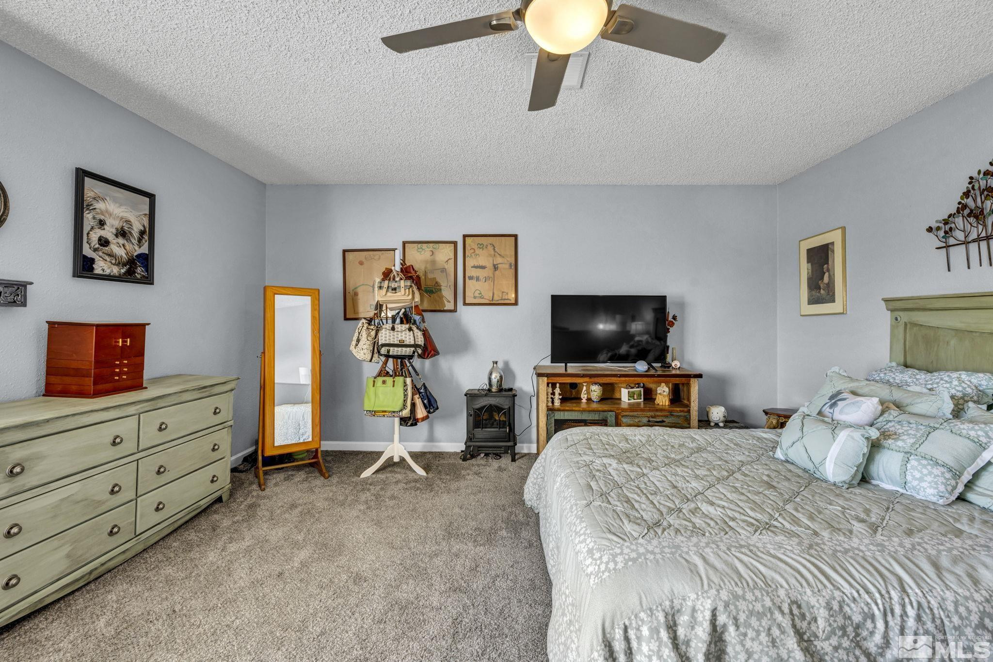 4721 Reggie Road Reno, NV 89502 - Photo 15 of 33 a bedroom with a bed and flat screen tv