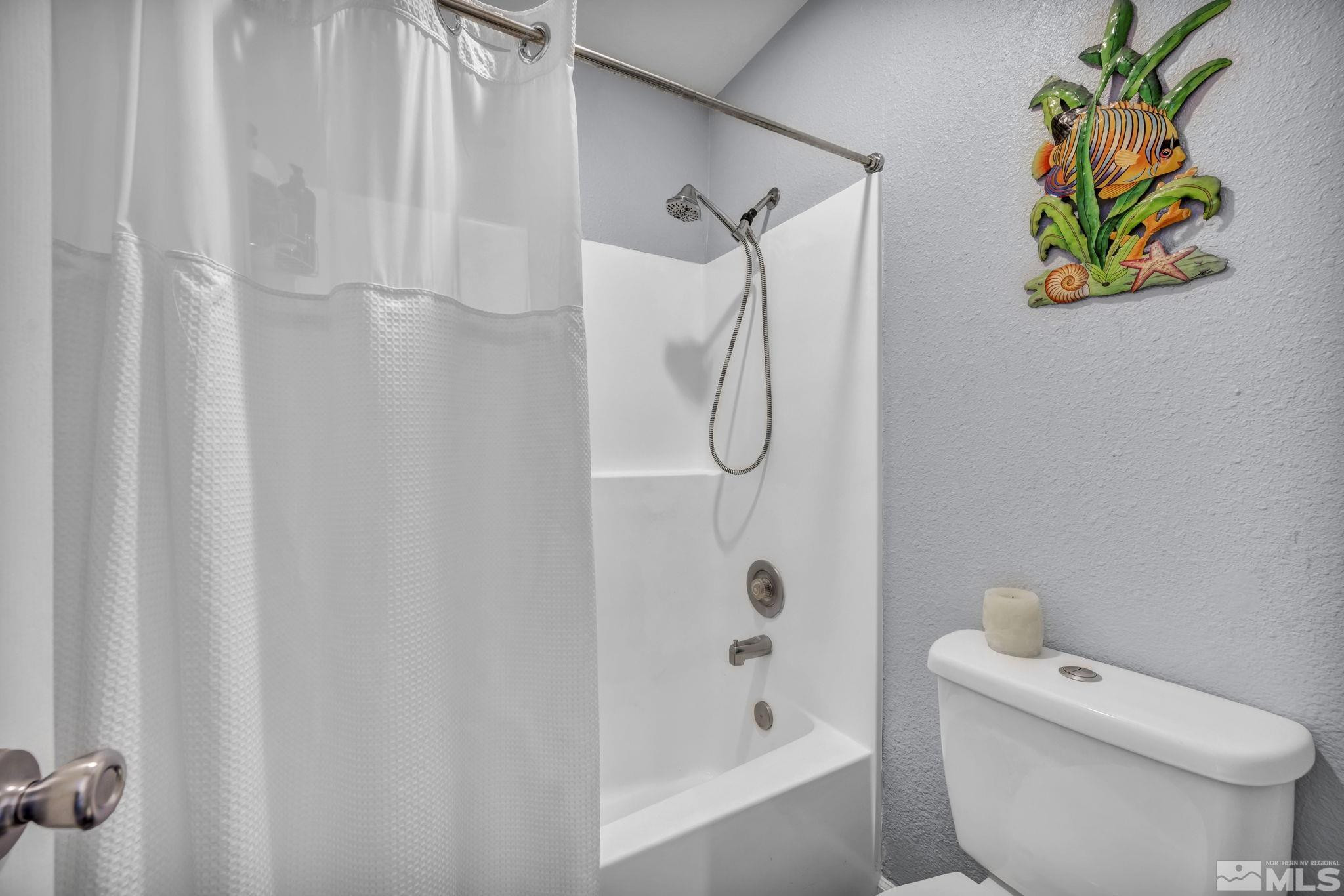 4721 Reggie Road Reno, NV 89502 - Photo 18 of 33 a white toilet sitting next to a bath tub