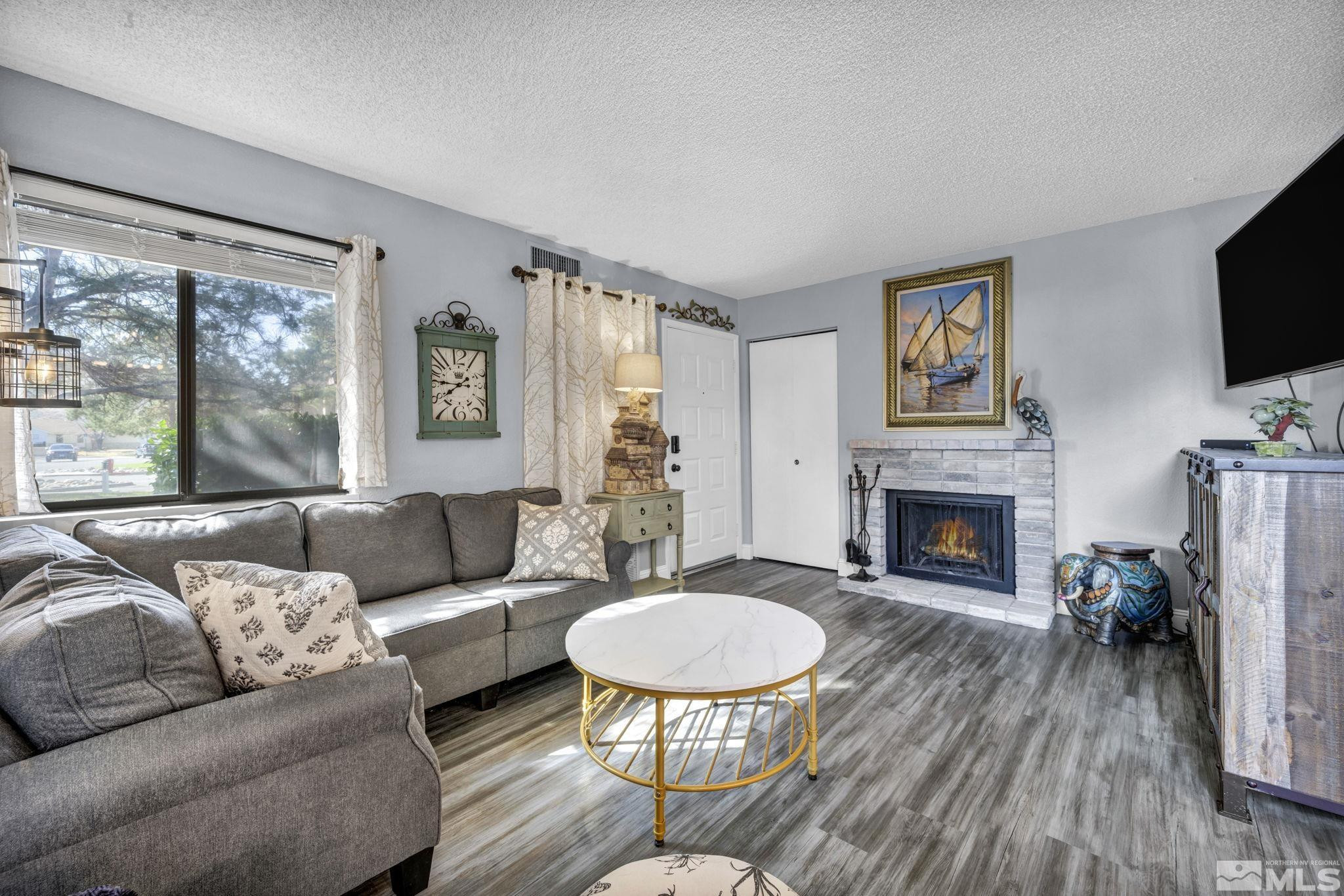 4721 Reggie Road Reno, NV 89502 - Photo 5 of 33 a living room with furniture a flat screen tv and a fireplace