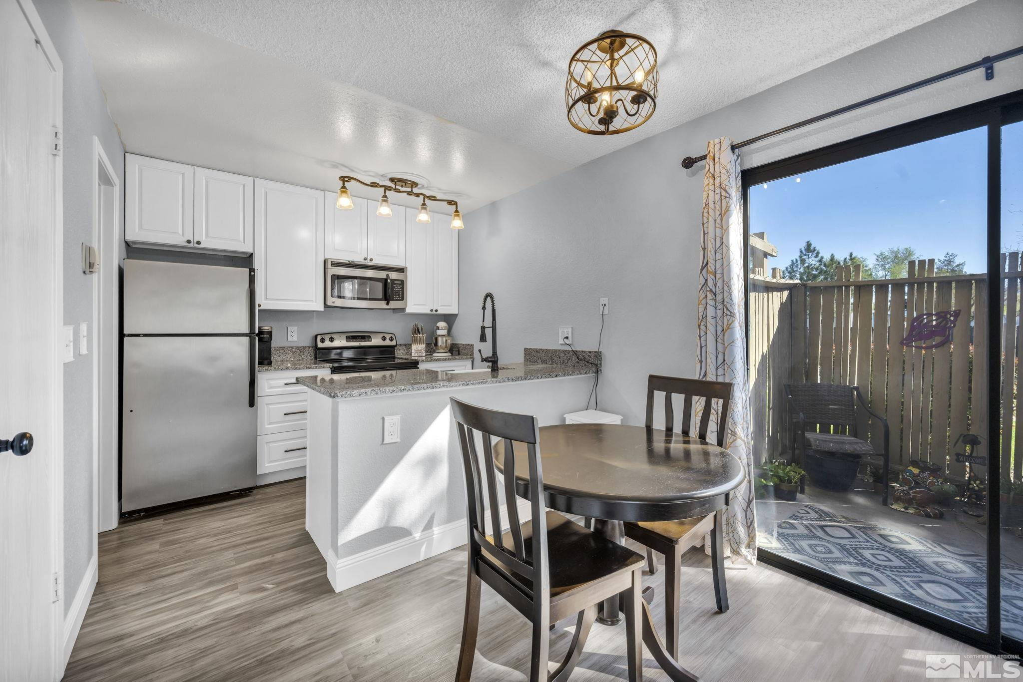 4721 Reggie Road Reno, NV 89502 - Photo 8 of 33 a kitchen with granite countertop a stove a refrigerator and a dining table
