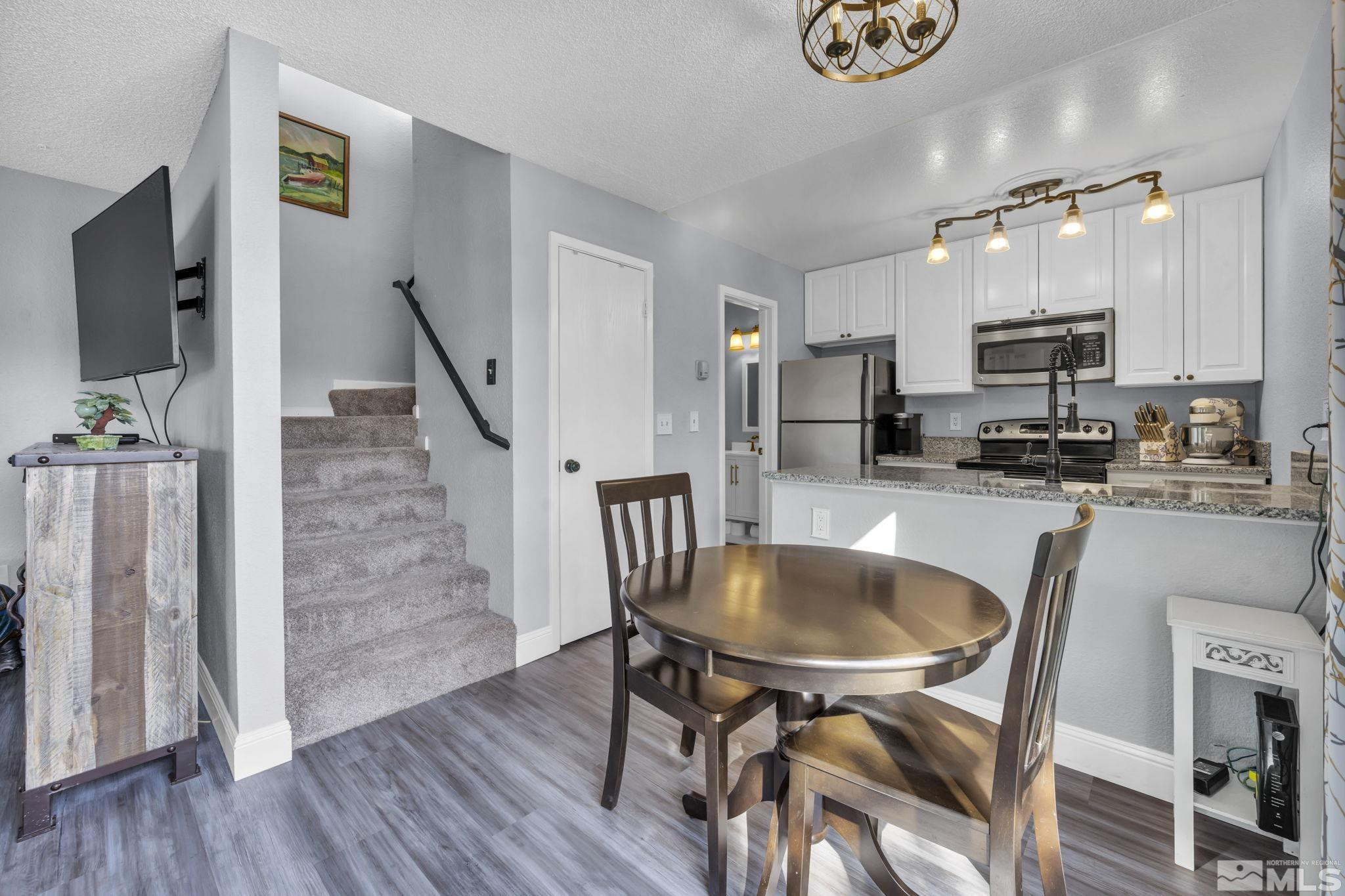4721 Reggie Road Reno, NV 89502 - Photo 9 of 33 a kitchen with granite countertop white cabinets and stainless steel appliances