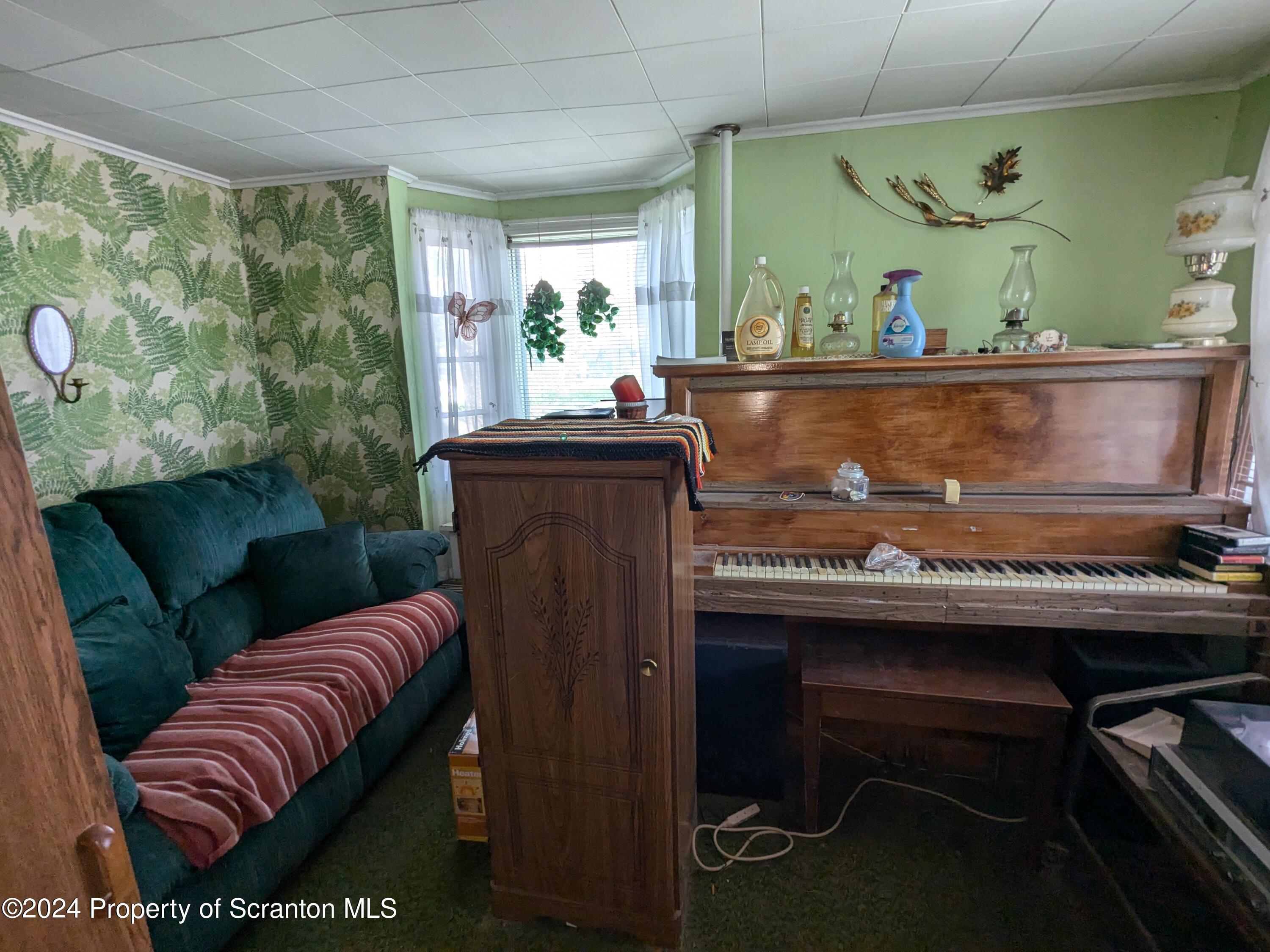 909 Battle Street Scranton, PA 18508 - Photo 4 of 11 a living room with a table chairs and a fireplace