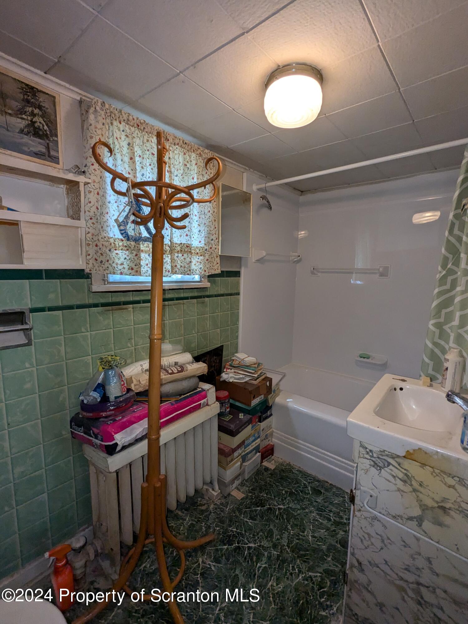 909 Battle Street Scranton, PA 18508 - Photo 7 of 11 a bathroom with a sink and a mirror