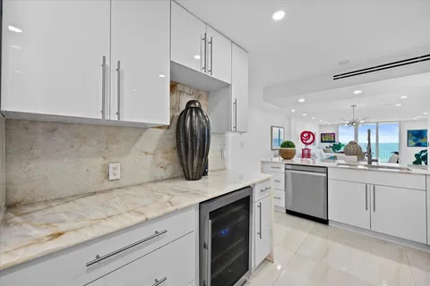 a kitchen with granite countertop white cabinets and white appliances