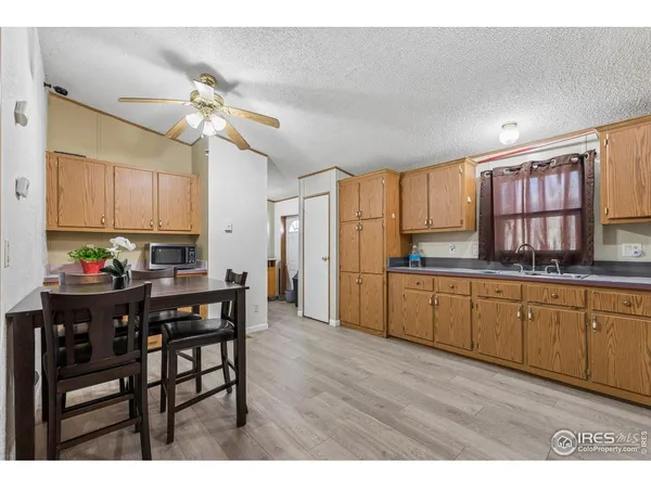 a kitchen with stainless steel appliances kitchen island granite countertop a table chairs refrigerator and sink