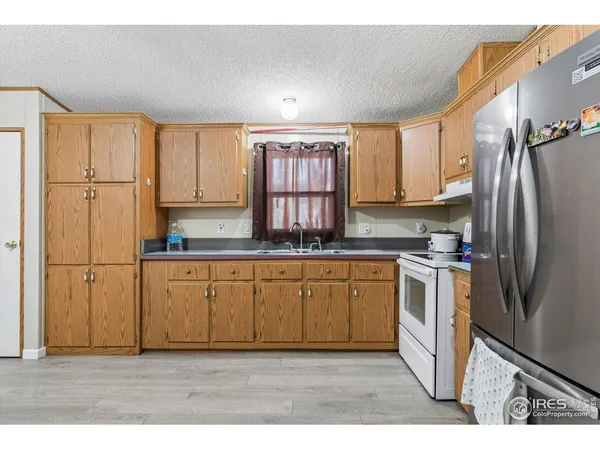 a kitchen with stainless steel appliances granite countertop a refrigerator sink and cabinets
