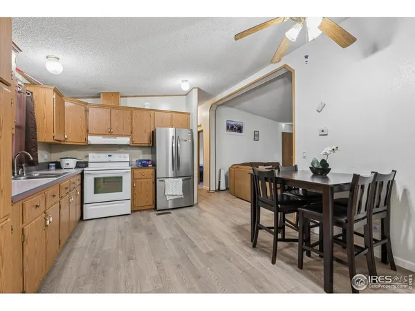 a kitchen with stainless steel appliances a dining table chairs and wooden floor
