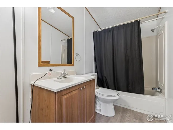 a bathroom with a sink a toilet a mirror and shower curtain