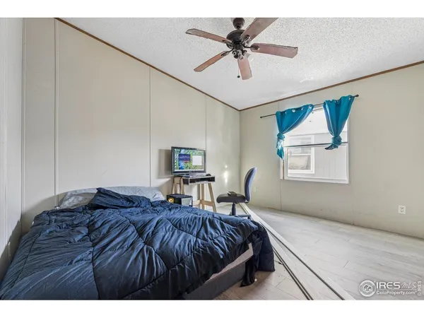 a bed room with a bed and a ceiling fan