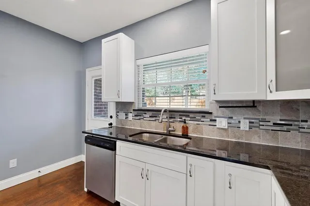 a kitchen with sink a window and cabinets