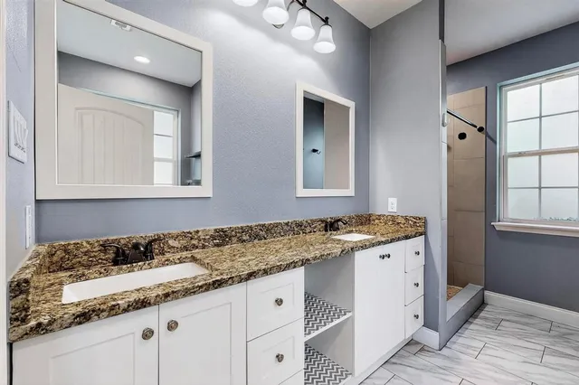 a bathroom with a granite countertop sink and a mirror