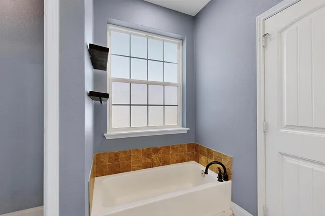a bathroom with a bathtub and a window