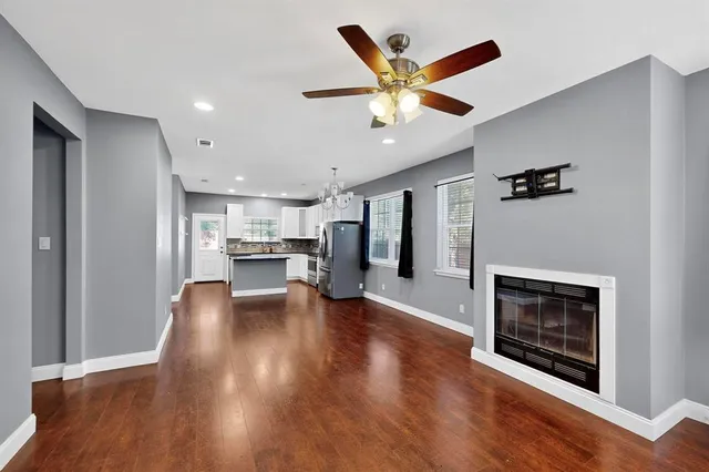 a view of a hallway with wooden floor and a fireplace