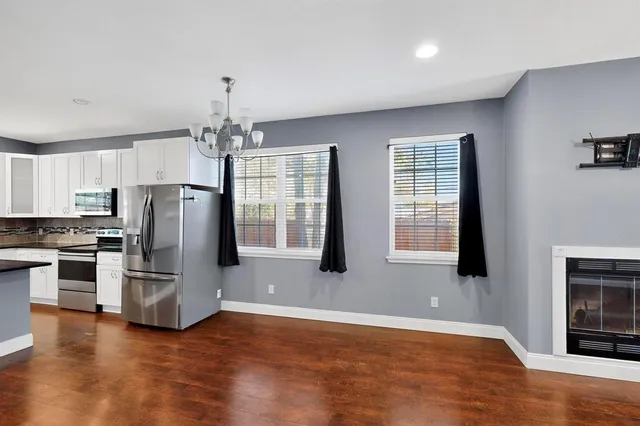 a open kitchen with granite countertop a refrigerator stove top oven and cabinets