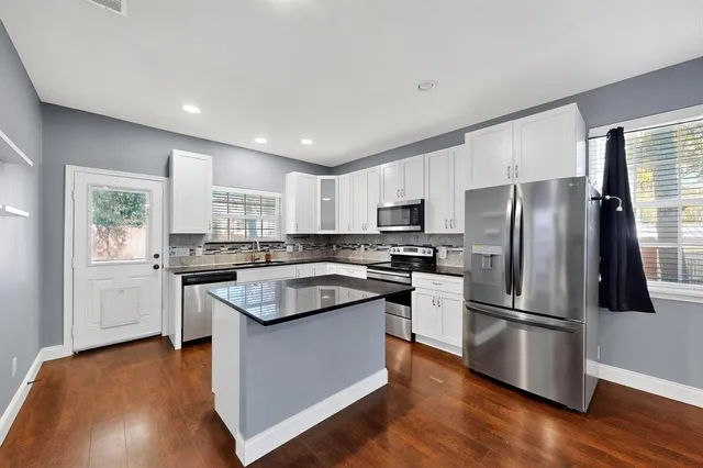a kitchen with a refrigerator sink and wooden floor