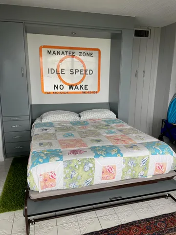 a bed with a painting on the wall