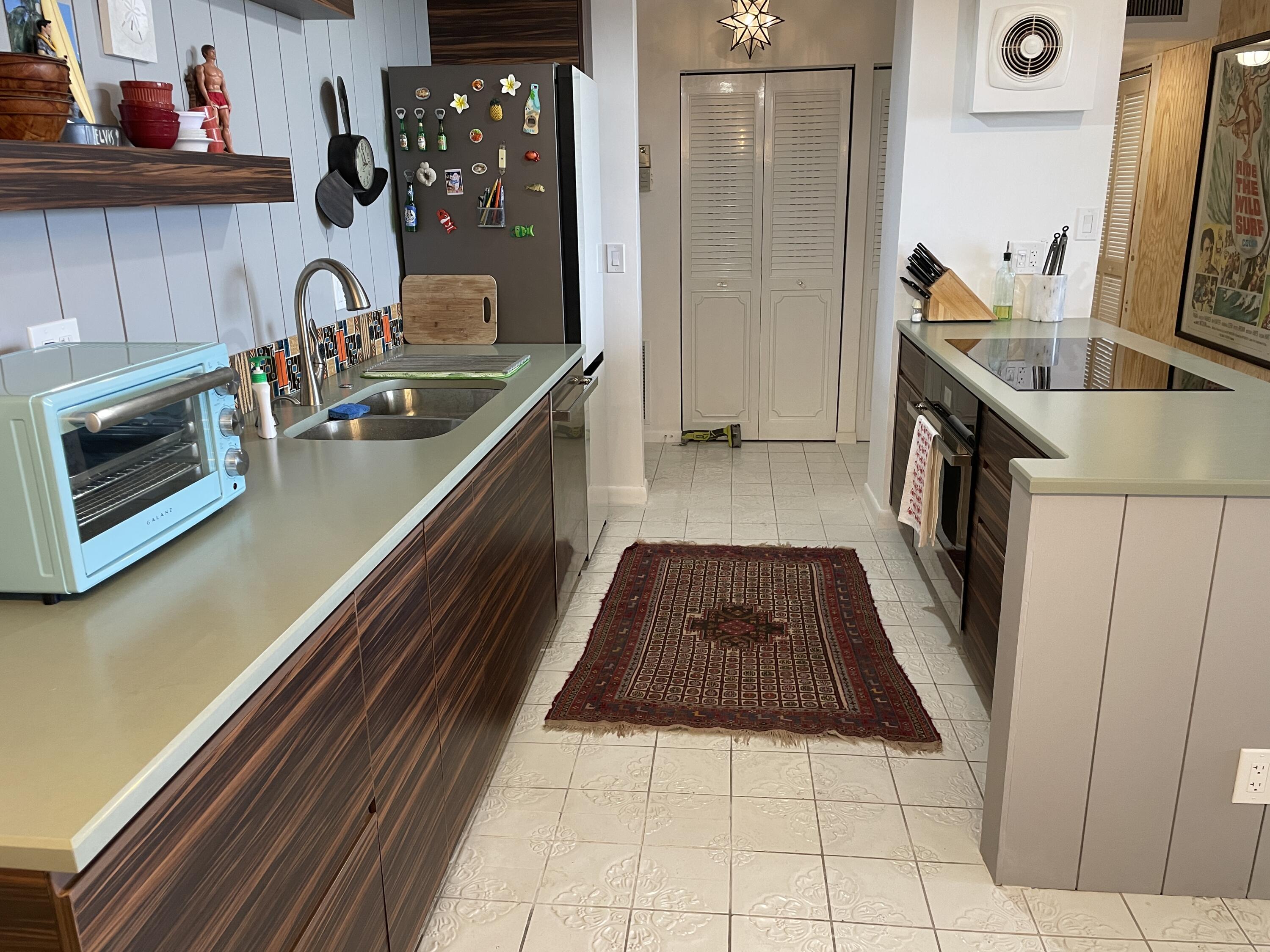 2121 North Ocean Boulevard, Unit 1204E Boca Raton, FL 33431 - Photo 7 of 21 a kitchen with a sink a stove and cabinets