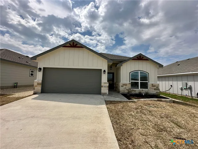a front view of a house with yard and garage