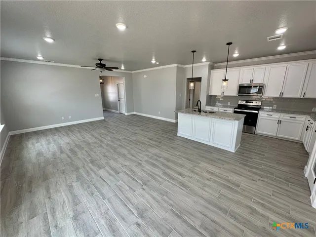 a large kitchen with kitchen island a sink dishwasher a refrigerator and a stove