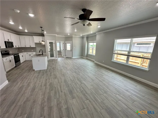 a view of a kitchen with a sink and wooden floor