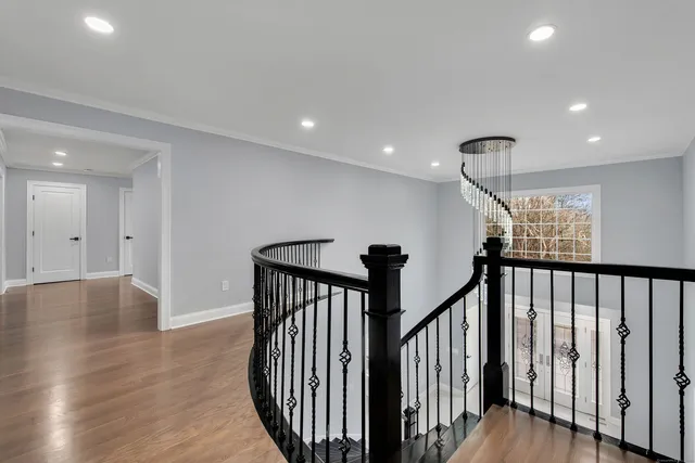 a view of a hallway with wooden floor and staircase