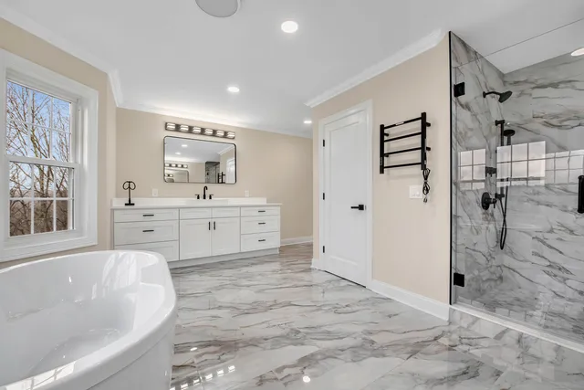 a spacious bathroom with a tub sink shower and mirror