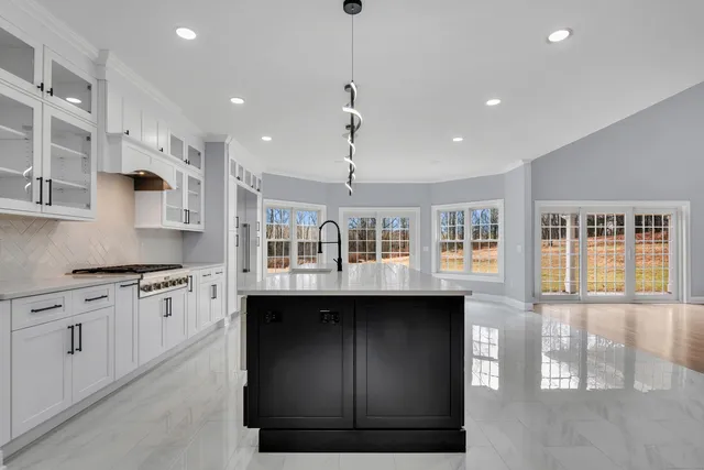 a kitchen with stainless steel appliances granite countertop a sink a stove and a wooden floors