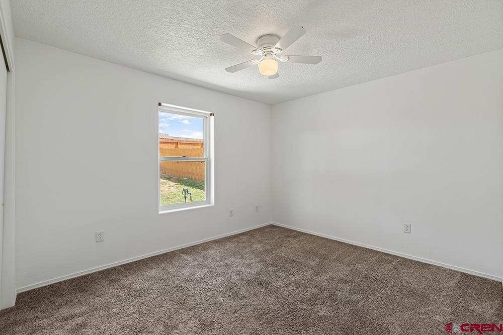 801 Hickory Ridge Bayfield, CO 81122 - Photo 20 of 32 an empty room with windows and ceiling fan
