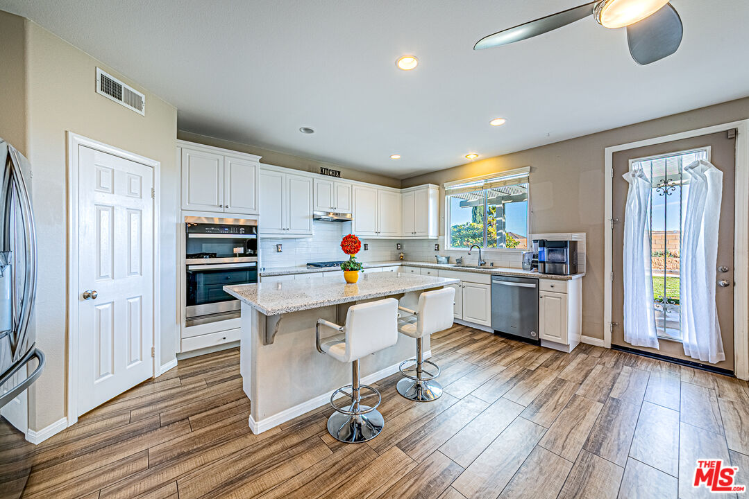 40918 Rise Court Palmdale, CA 93551 - Photo 11 of 45 a kitchen with a sink appliances cabinets and wooden floor
