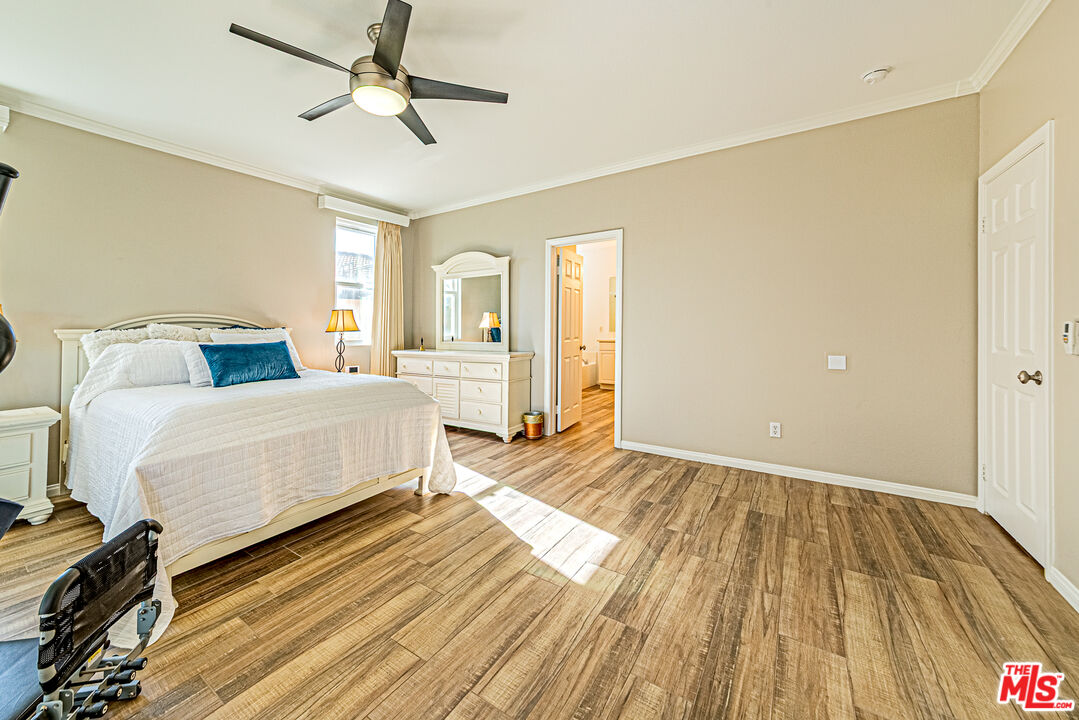 40918 Rise Court Palmdale, CA 93551 - Photo 21 of 45 a bedroom with a bed and wooden floor