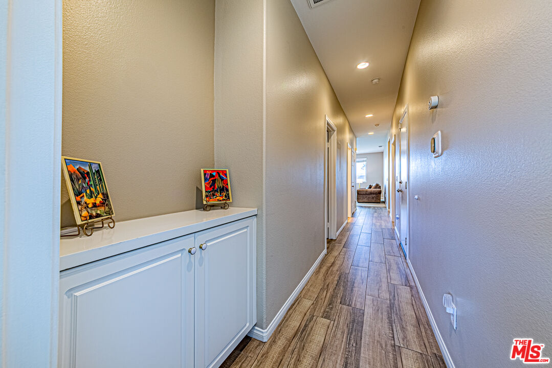 40918 Rise Court Palmdale, CA 93551 - Photo 27 of 45 a hallway view with wooden floor and staircase