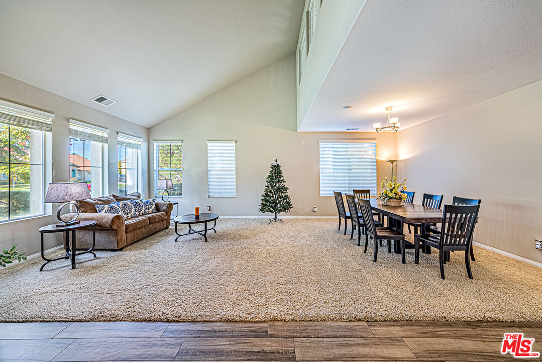 40918 Rise Court Palmdale, CA 93551 - Photo 6 of 45 a living room with furniture a dining table and a potted plant with wooden floor