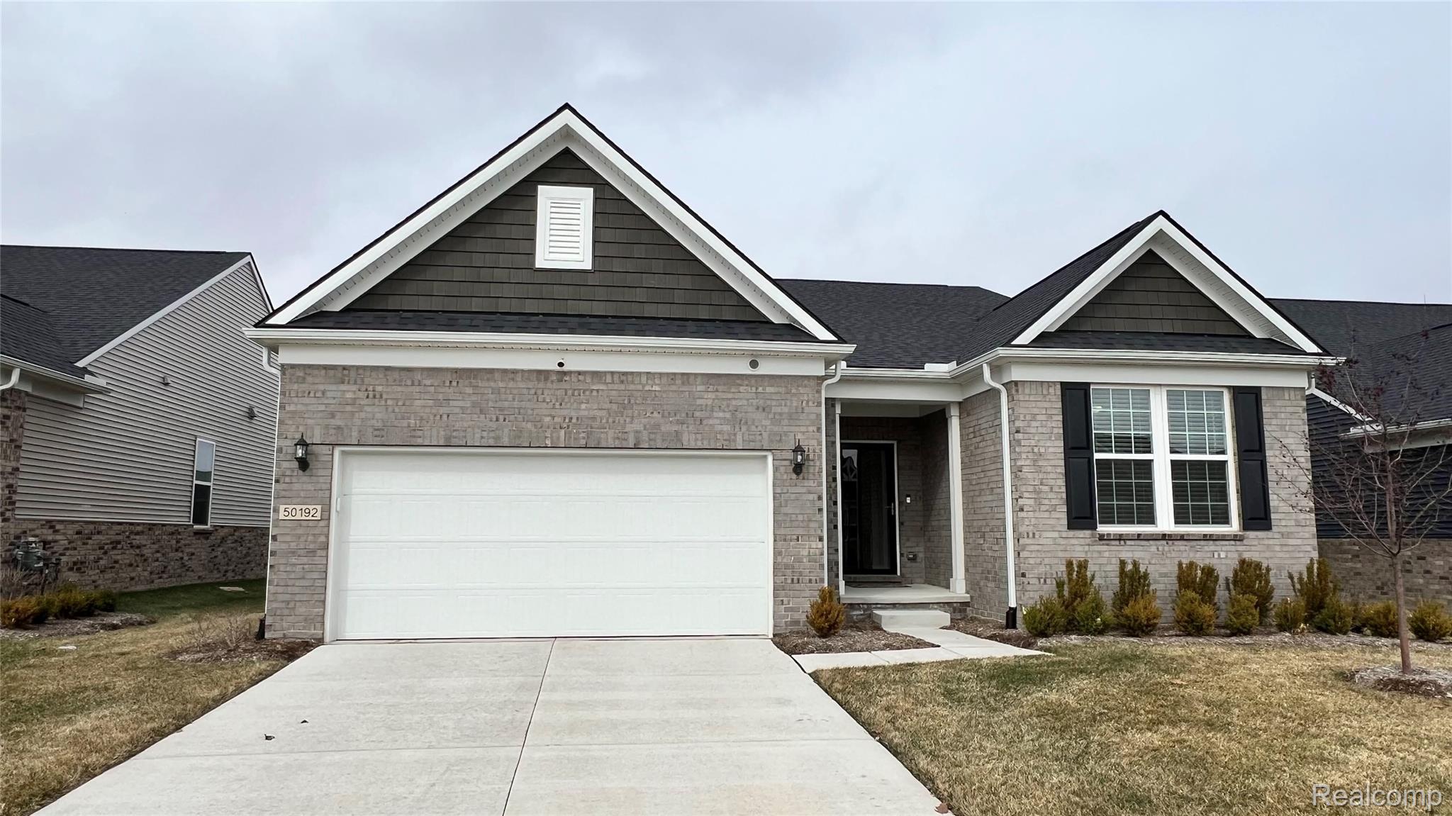 50192 Ogden Road Canton, MI 48188 - Photo 1 of 28 View of front of property featuring concrete driveway, brick siding, a front lawn, and a garage