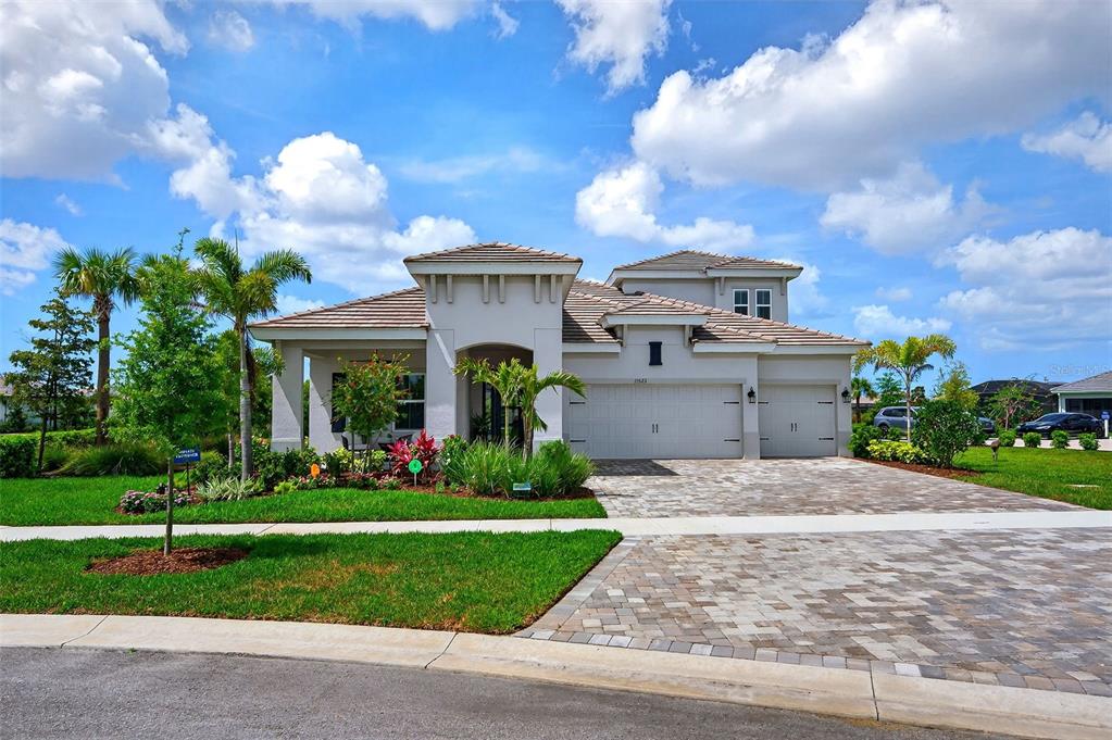 a front view of a house with a garden and trees