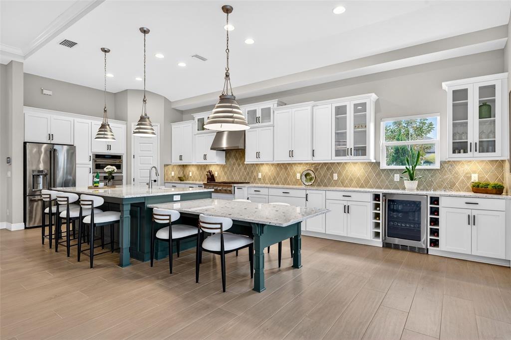 11523 Gleaming Terrace Venice, FL 34293 - Photo 20 of 83 a kitchen with stainless steel appliances kitchen island granite countertop a table chairs sink and cabinets