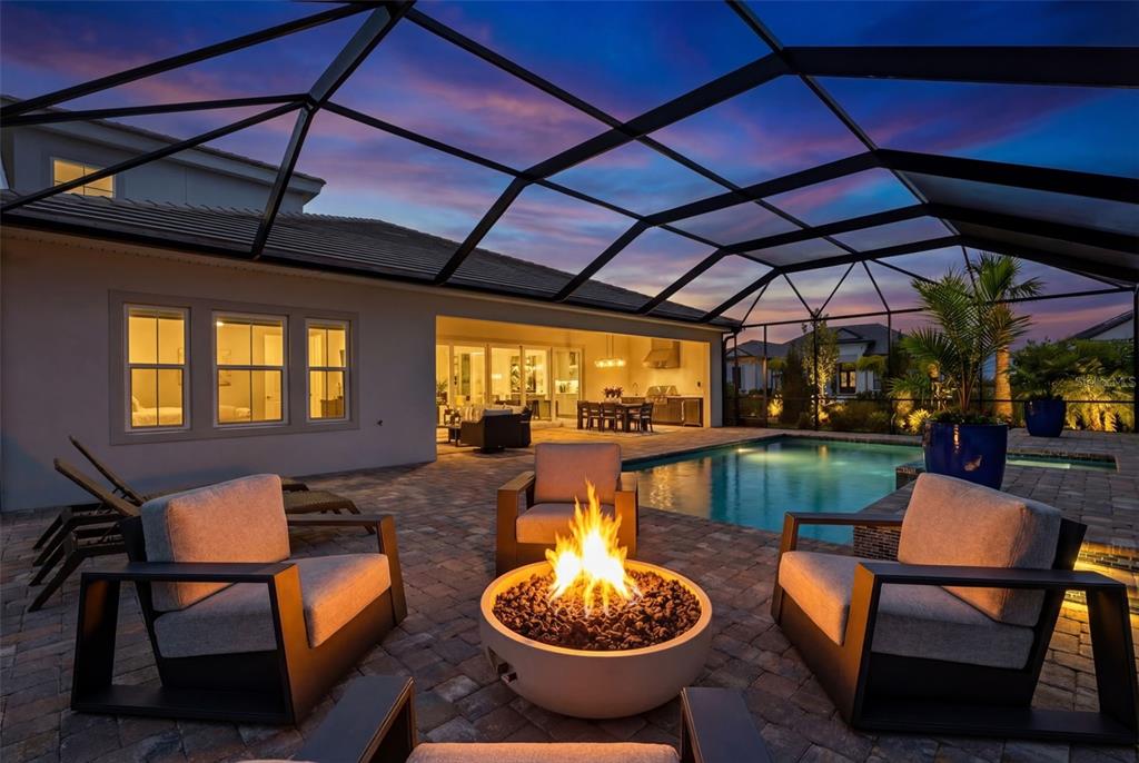 11523 Gleaming Terrace Venice, FL 34293 - Photo 39 of 83 a view of a patio with a dining table and chairs with a barbeque grill and a fireplace