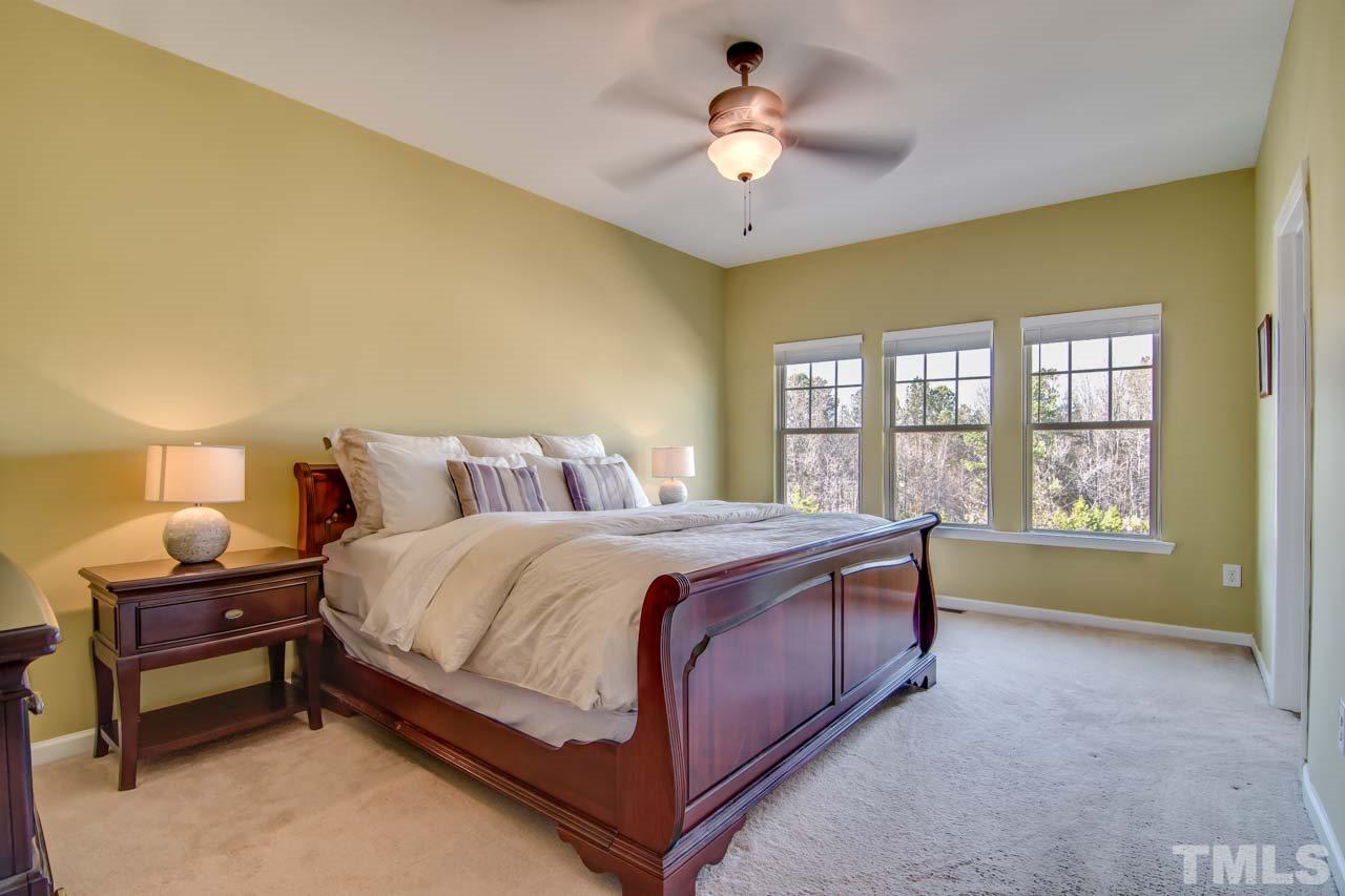 1308 Cornell Place Raleigh, NC 27607 - Photo 12 of 25 a spacious bedroom with a bed and a chandelier