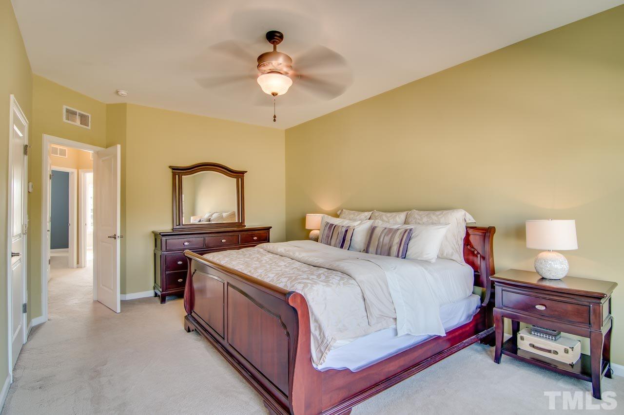 1308 Cornell Place Raleigh, NC 27607 - Photo 13 of 25 a spacious bedroom with a bed and a chandelier